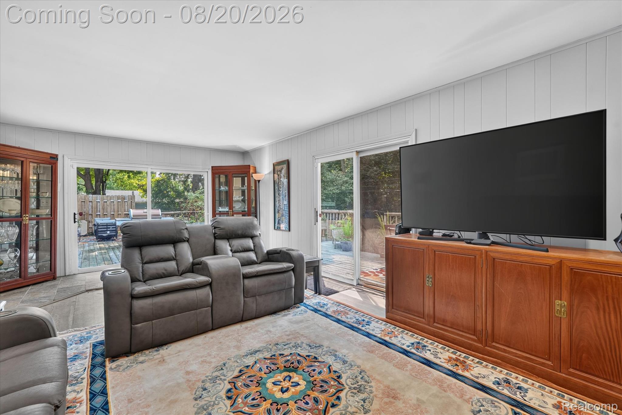 6235 Waldon Road Clarkston, MI 48346 - Photo 13 of 41 Sliding glass door leading to outdoor decking, white paneled walls, and wood cabinetry