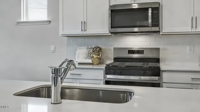 a kitchen with stainless steel appliances granite countertop a stove and a microwave