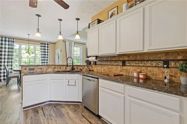 a kitchen with stainless steel appliances granite countertop a sink a stove and cabinets