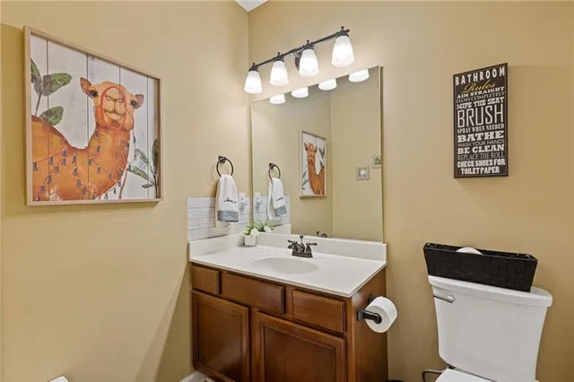 a bathroom with a sink mirror and a toilet