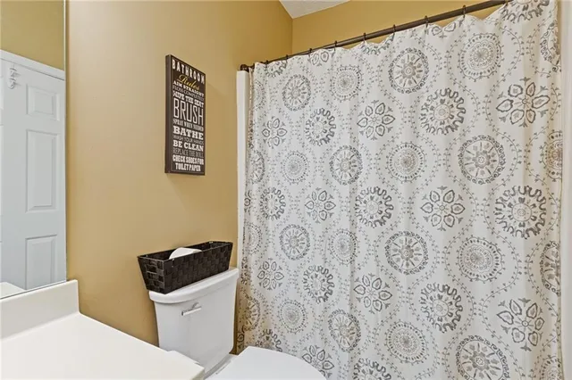 a white toilet sitting next to a shower curtain