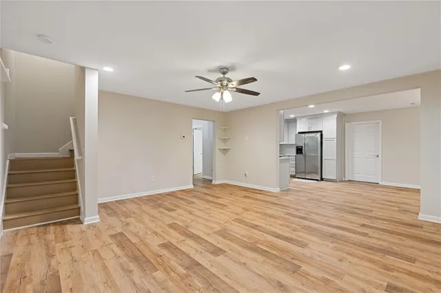 a view of an empty room with a window and wooden floor