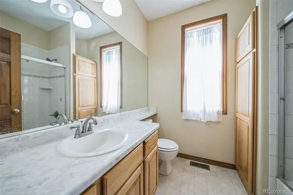 a bathroom with a granite countertop sink toilet and shower