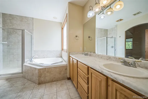 a bathroom with a granite countertop sink a large mirror and a bathtub