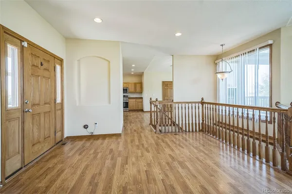 a view of a hallway with wooden floor and windows
