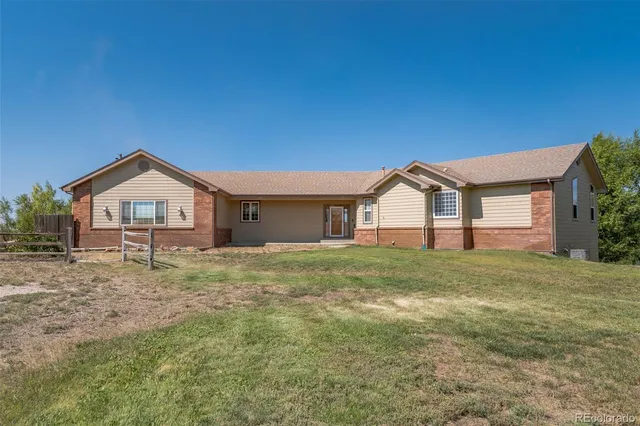 a view of a big house with a big yard and large trees