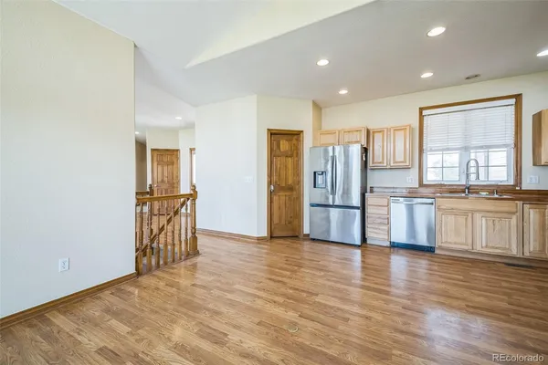 a view of a kitchen with stainless steel appliances wooden floor and a window