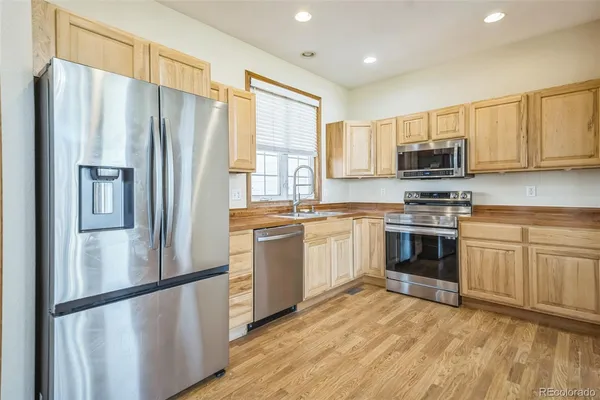 a kitchen with stainless steel appliances a refrigerator sink and microwave
