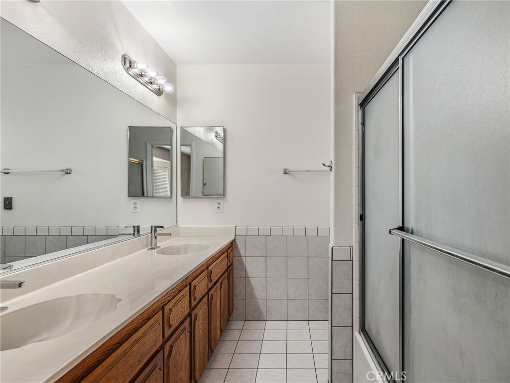 9550 Riggins Road Phelan, CA 92371 - Photo 23 of 47 a bathroom with a double vanity sink a mirror and a shower