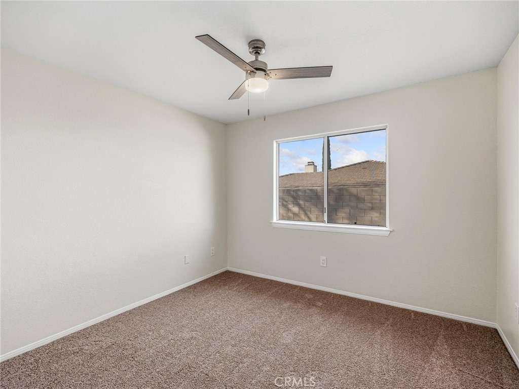 9550 Riggins Road Phelan, CA 92371 - Photo 29 of 47 an empty room with ceiling fan and windows