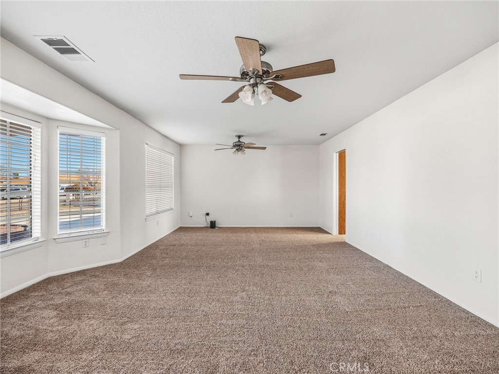 9550 Riggins Road Phelan, CA 92371 - Photo 3 of 47 an empty room with windows and fan