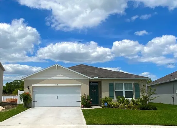 a view of a white house next to a yard