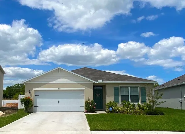 a view of a white house next to a yard