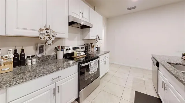 a kitchen with kitchen island granite countertop a sink a counter top space and cabinets