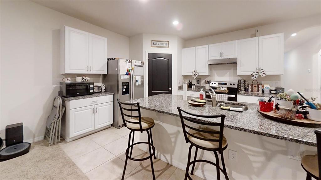 1818 Myrtlebrooke Drive Edgewater, FL 32141 - Photo 12 of 23 a kitchen with refrigerator and cabinets