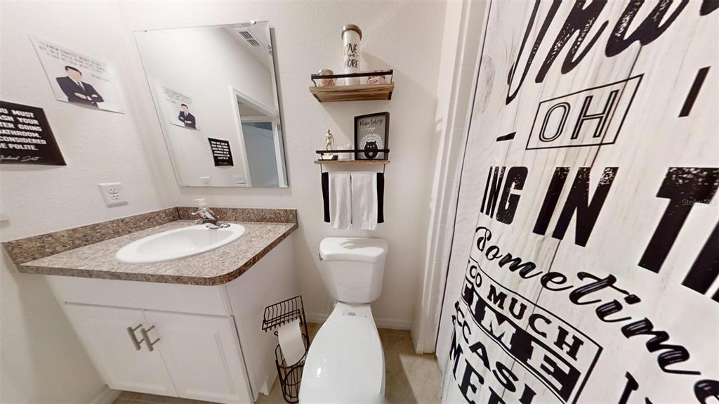 1818 Myrtlebrooke Drive Edgewater, FL 32141 - Photo 18 of 23 a bathroom with a sink and mirror with toilet