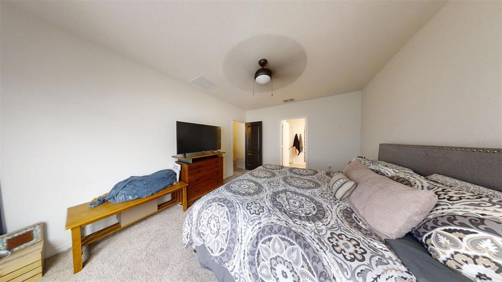 1818 Myrtlebrooke Drive Edgewater, FL 32141 - Photo 19 of 23 a bedroom with a bed and a flat screen tv