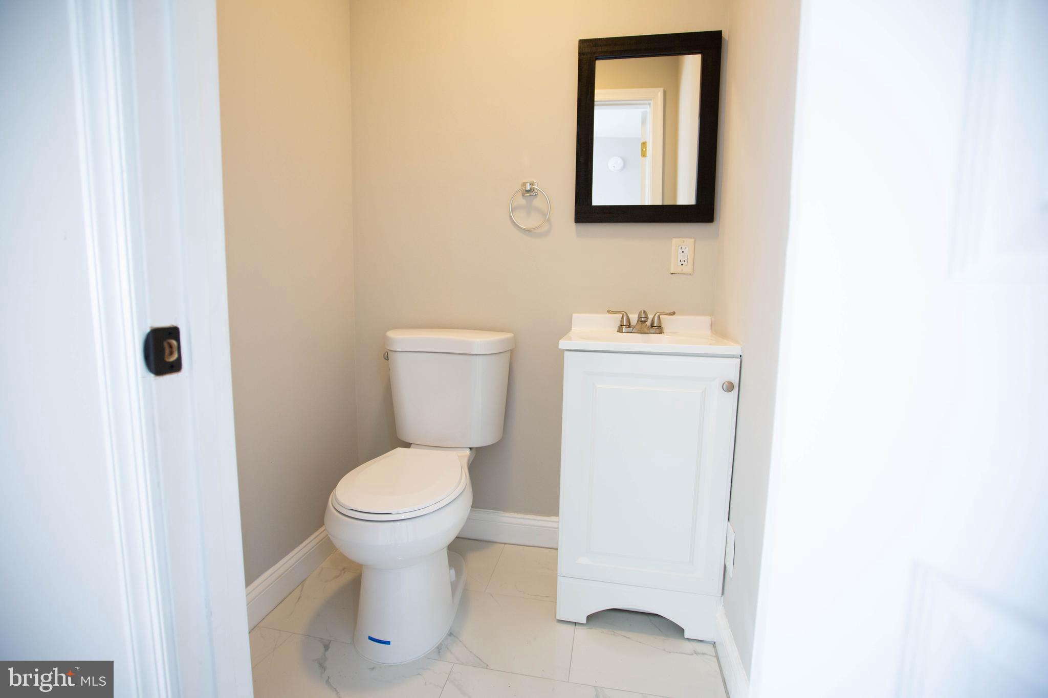 5035 West Hills Road Baltimore, MD 21229 - Photo 15 of 21 a bathroom with a toilet sink and mirror