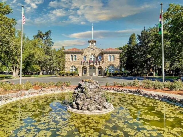 a view of a swimming pool with a bench and trees around