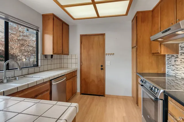 a kitchen with stainless steel appliances granite countertop a sink and a refrigerator