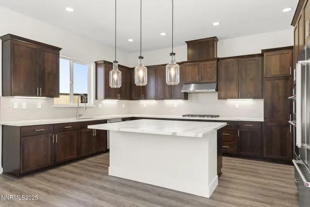 a kitchen with stainless steel appliances granite countertop a sink a stove and a refrigerator