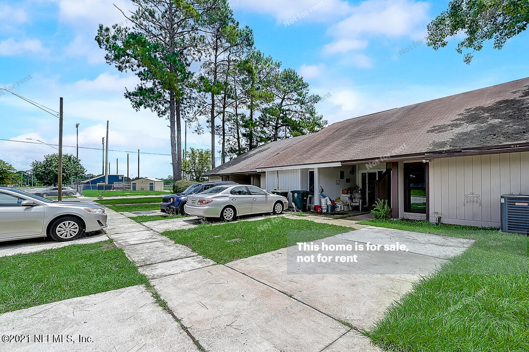 10740 Alden Road, Unit 4 Jacksonville, FL 32246 - Photo 11 of 28 a view of a white house with a yard plants and palm trees
