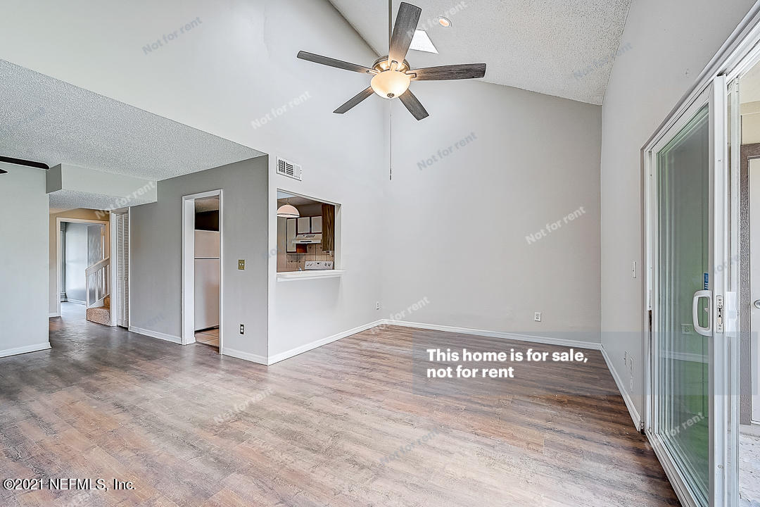 10740 Alden Road, Unit 4 Jacksonville, FL 32246 - Photo 5 of 28 wooden floor in an empty room with a chandelier fan