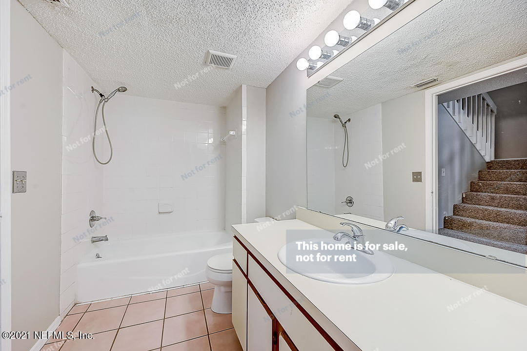 10740 Alden Road, Unit 4 Jacksonville, FL 32246 - Photo 7 of 28 a bathroom with a granite countertop sink a shower and a mirror