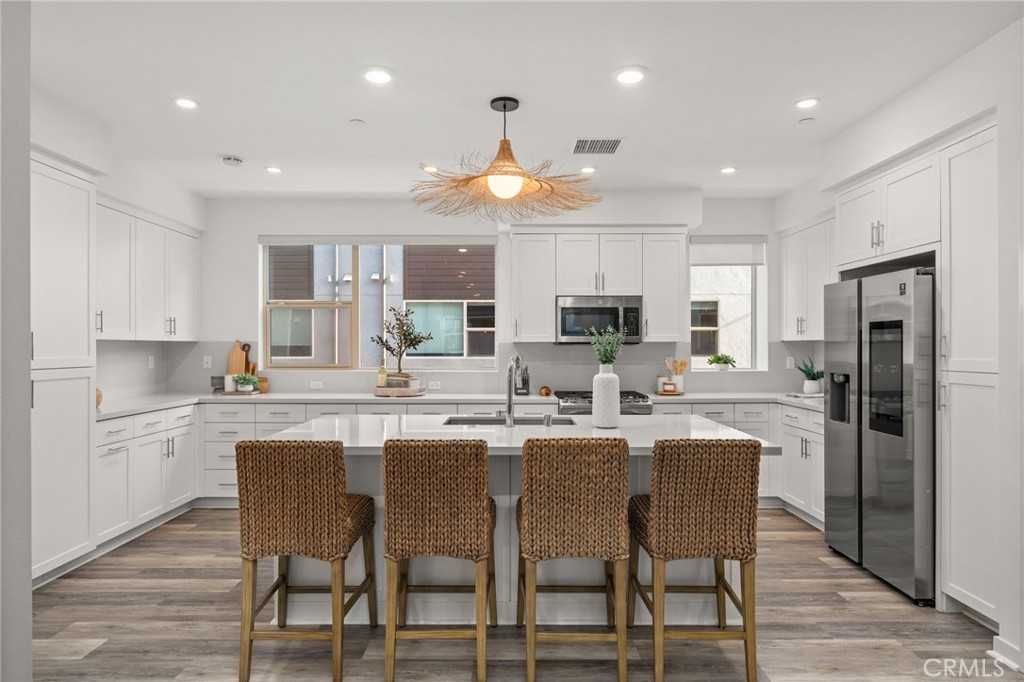 217 Placemark Irvine, CA 92614 - Photo 11 of 39 a kitchen with stainless steel appliances granite countertop a dining table chairs refrigerator and cabinets