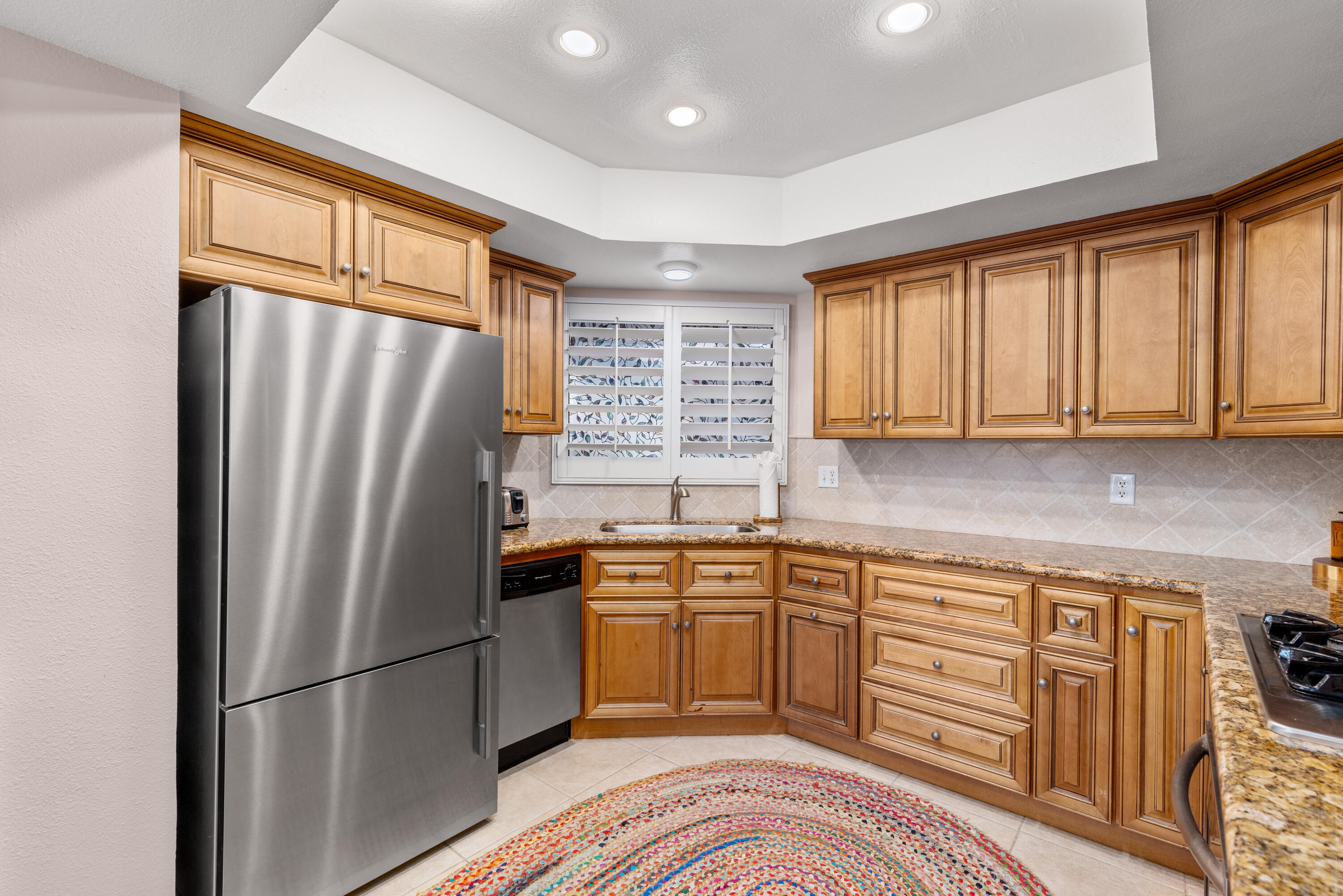 71828 Eleanora Lane Rancho Mirage, CA 92270 - Photo 12 of 37 a kitchen with stainless steel appliances granite countertop a refrigerator and wooden cabinets