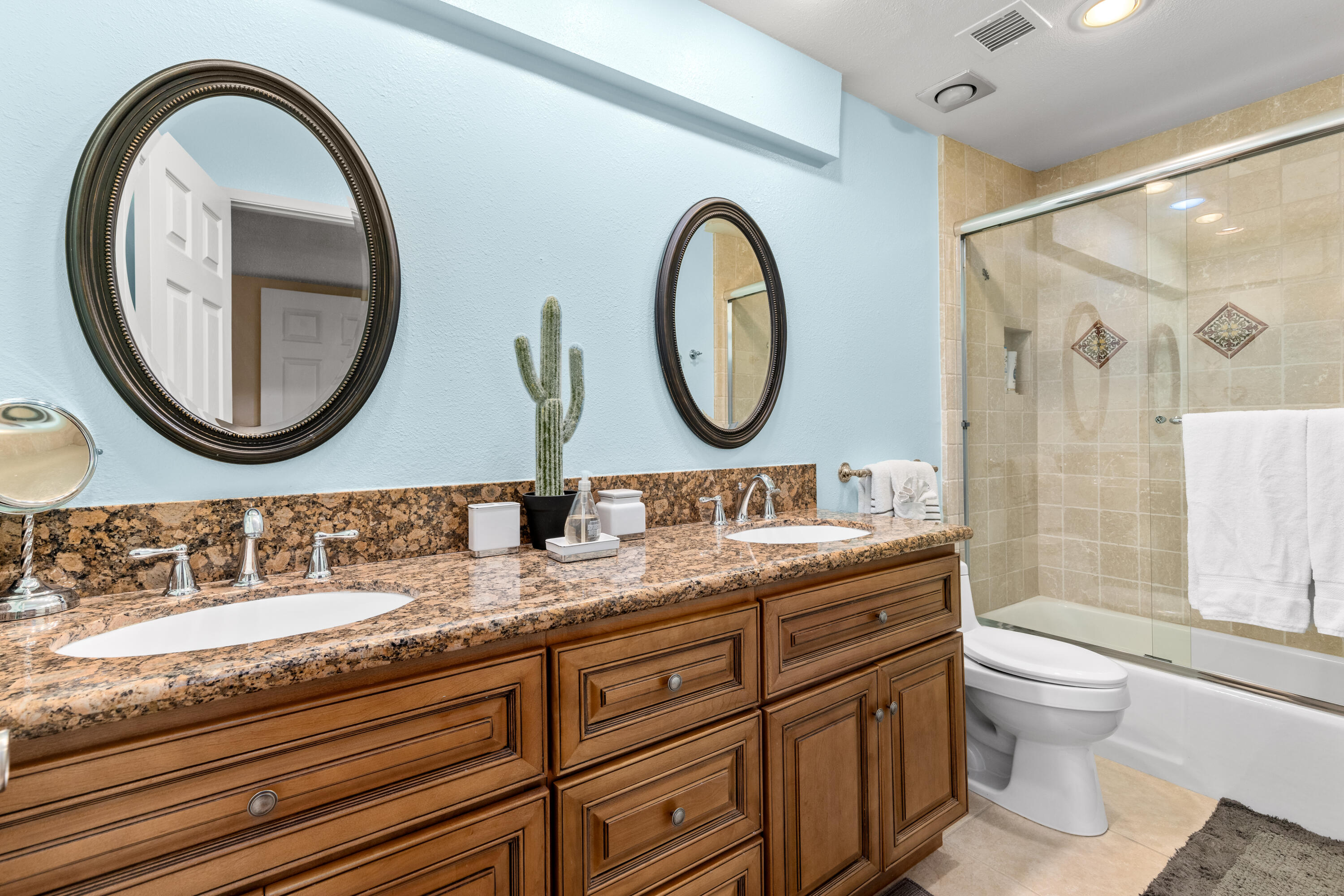 71828 Eleanora Lane Rancho Mirage, CA 92270 - Photo 19 of 37 a bathroom with a granite countertop toilet a sink a mirror and a shower