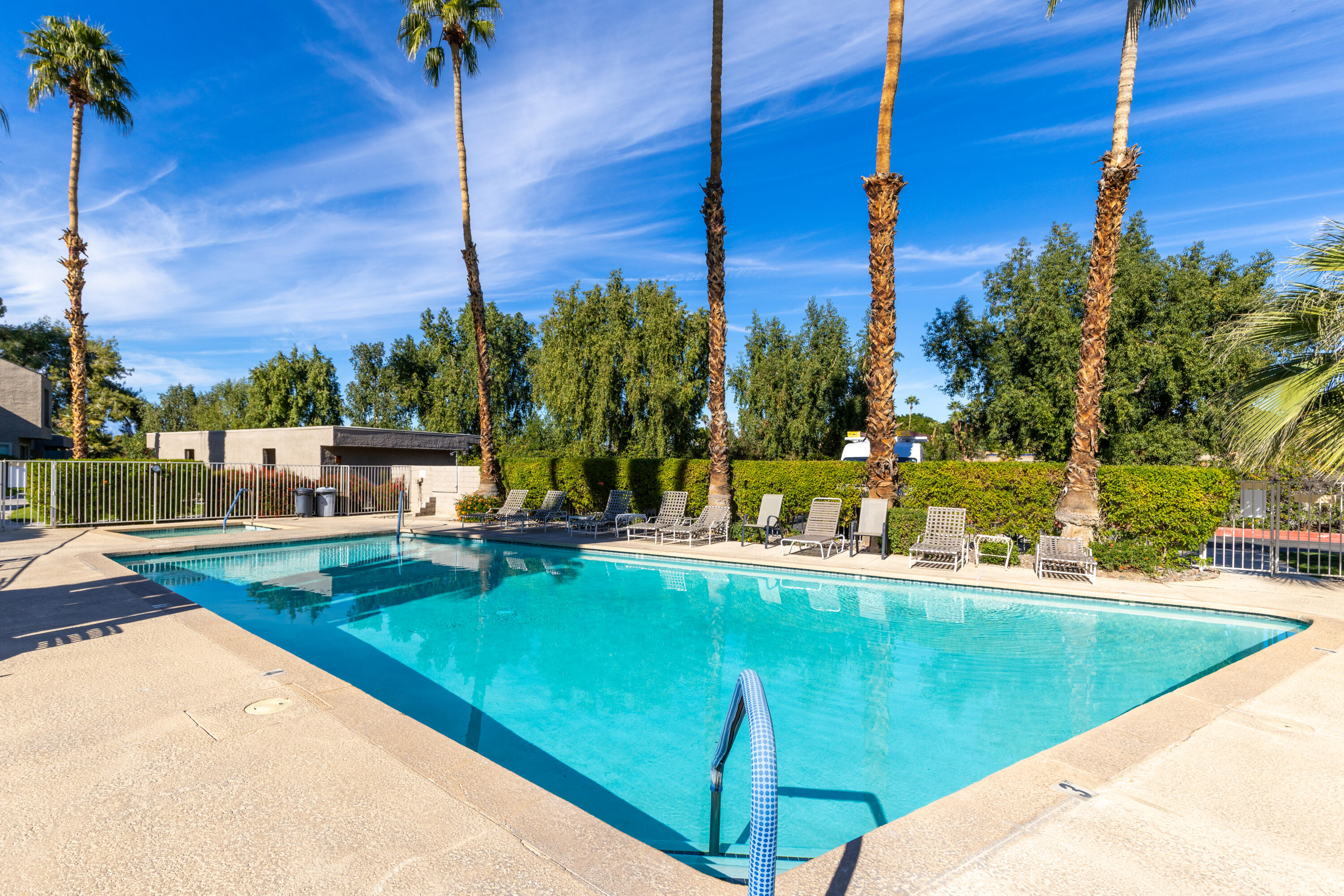 71828 Eleanora Lane Rancho Mirage, CA 92270 - Photo 32 of 37 a view of a swimming pool with a bench and trees around