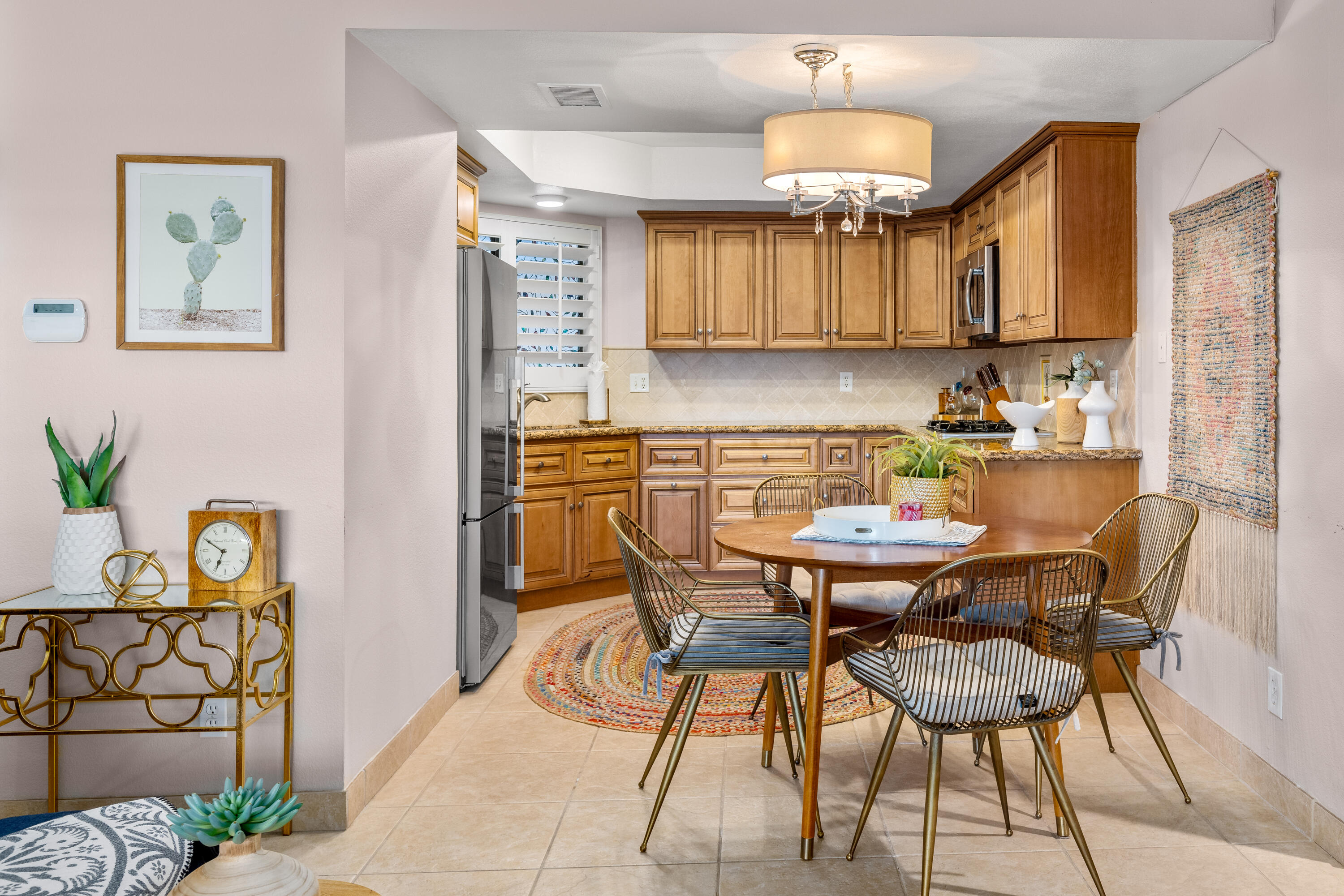 71828 Eleanora Lane Rancho Mirage, CA 92270 - Photo 9 of 37 a kitchen with stainless steel appliances a dining table and chairs with wooden floor
