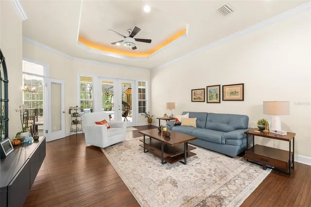 a dining room with furniture a chandelier and wooden floor