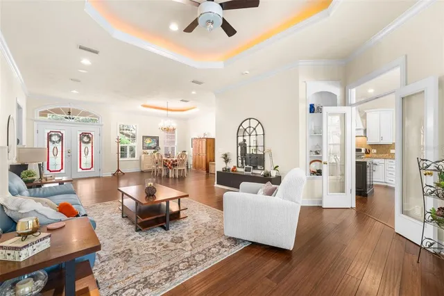 a view of a dining room and livingroom with furniture wooden floor a chandelier