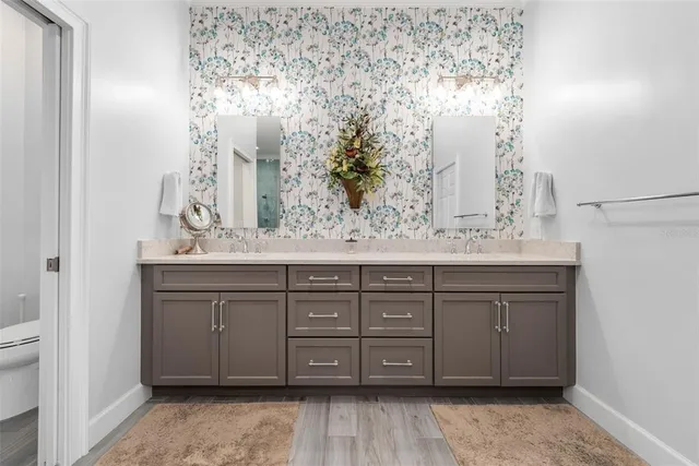a bathroom with a granite countertop sink toilet and mirror