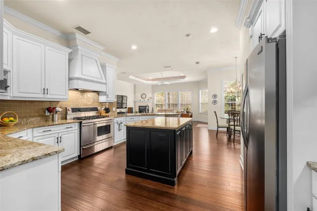 a kitchen with granite countertop cabinets stainless steel appliances and wooden floor