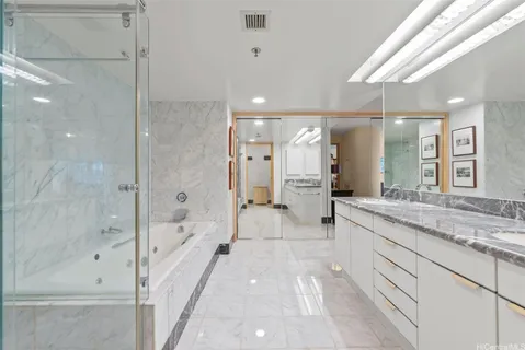 a bathroom with a granite countertop sink a mirror a bathtub and shower