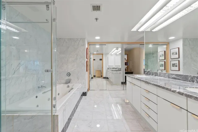 a bathroom with a granite countertop sink a mirror a bathtub and shower