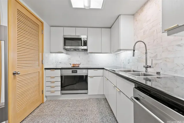 a kitchen with stainless steel appliances granite countertop a sink and a stove