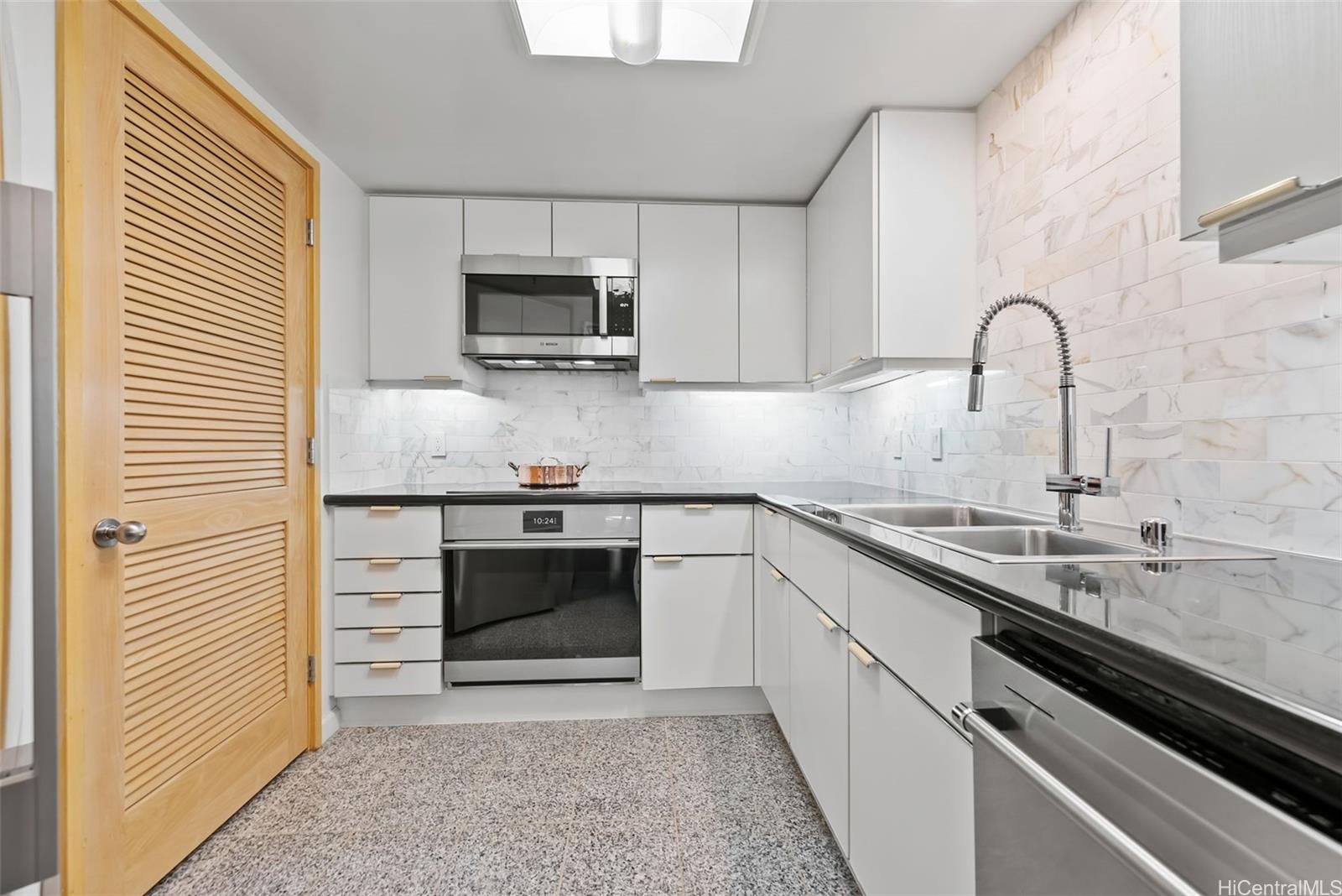 1888 Kalakaua Avenue, Unit 907 Honolulu, HI 96815 - Photo 4 of 25 a kitchen with stainless steel appliances granite countertop a sink and a stove
