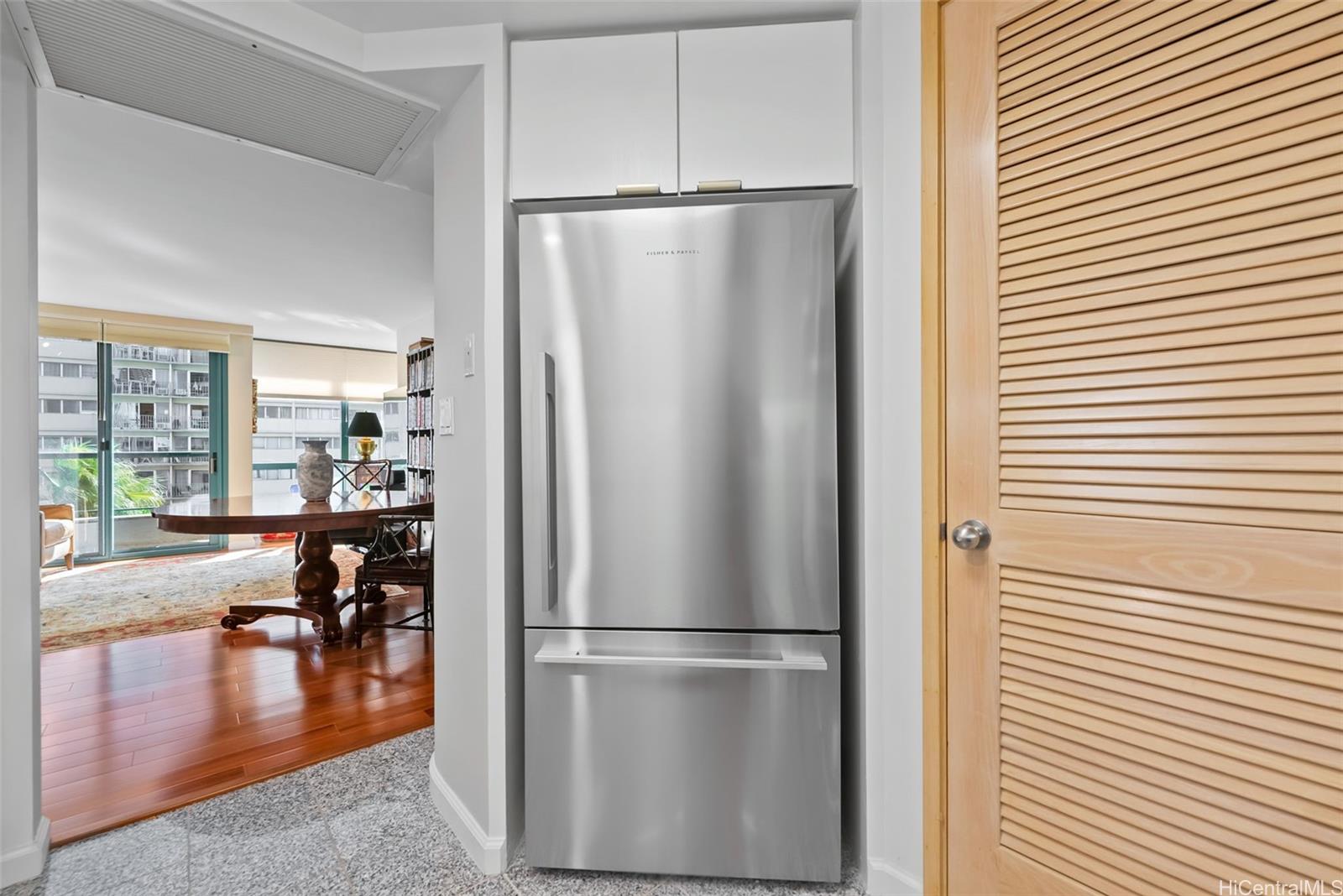 1888 Kalakaua Avenue, Unit 907 Honolulu, HI 96815 - Photo 5 of 25 a kitchen with stainless steel appliances a refrigerator and wooden floor