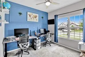 a view of a workspace with furniture and a window