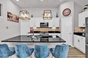 a kitchen with stainless steel appliances granite countertop a granite counter tops and a view of living room