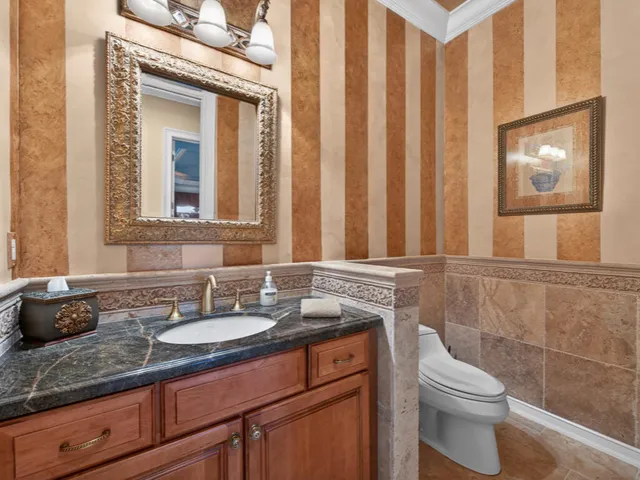 a bathroom with a granite countertop sink toilet and mirror