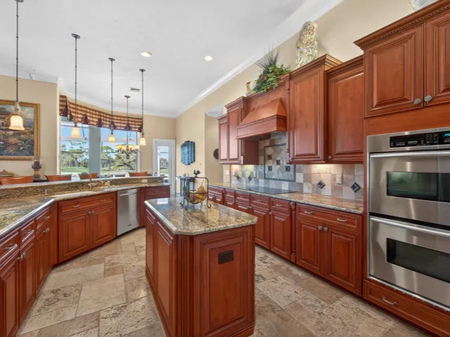 a kitchen with stainless steel appliances granite countertop a sink a stove and a wooden cabinets