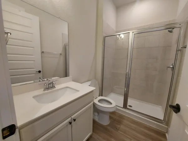 a bathroom with a sink a toilet and shower