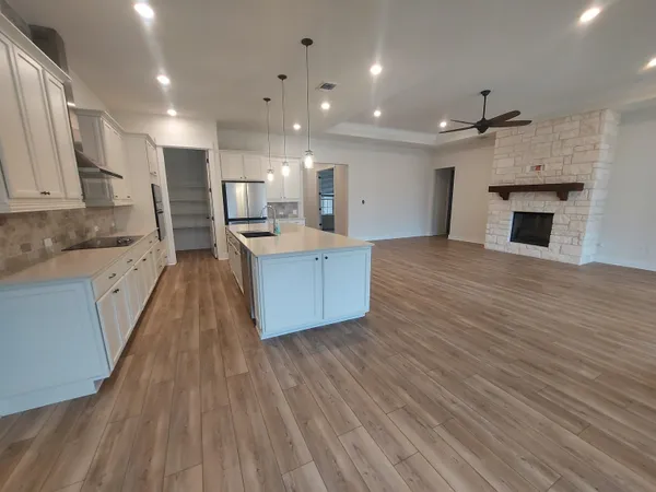 a large kitchen with granite countertop a large counter top stainless steel appliances and cabinets