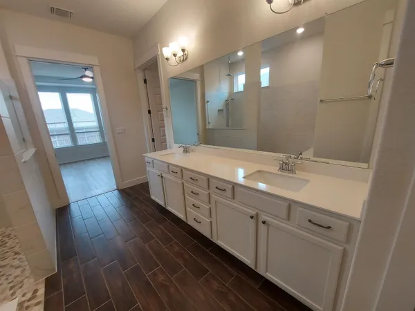 a spacious bathroom with double vanity and a mirror