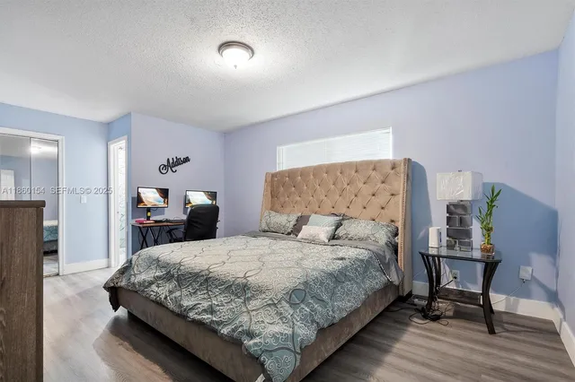 a bedroom with a bed a mirror and a couch